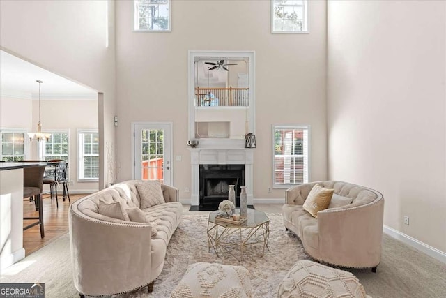3113 Brians Creek Dr SE, Conyers, GA 30013 - living area with a towering ceiling, a chandelier, a fireplace, plenty of natural light, and a ceiling fan