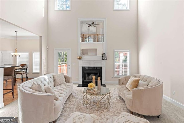 3113 Brians Creek Dr SE, Conyers, GA 30013 - living room featuring a towering ceiling, a chandelier, a fireplace, crown molding, and ceiling fan