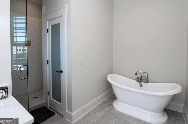 603 W 1st St, Rome, GA 30161 - bathroom with a freestanding tub, a stall shower, and baseboards