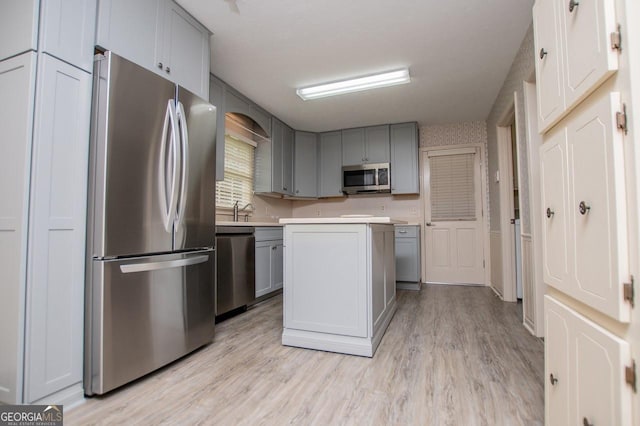 65 Pine Haven Ct, Carrollton, GA 30116 - kitchen featuring appliances with stainless steel finishes, gray cabinetry, light wood-style flooring, and light countertops