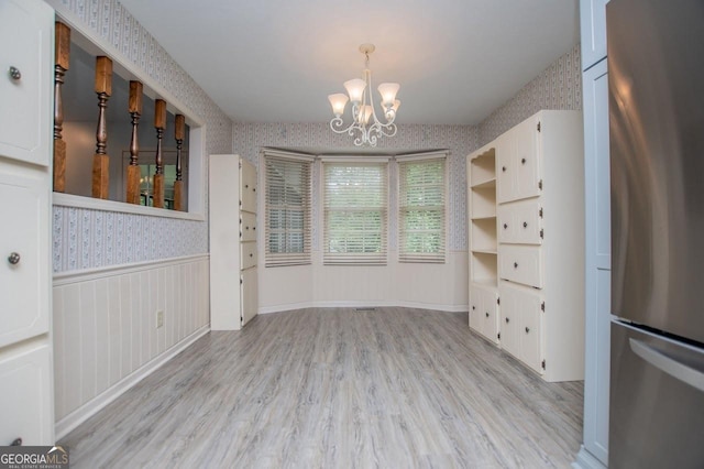 65 Pine Haven Ct, Carrollton, GA 30116 - unfurnished dining area featuring wallpapered walls, a wainscoted wall, a chandelier, and light wood-style flooring