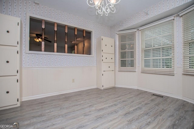 65 Pine Haven Ct, Carrollton, GA 30116 - unfurnished dining area with wallpapered walls, wainscoting, a chandelier, wood finished floors, and a ceiling fan