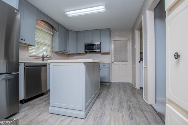 65 Pine Haven Ct, Carrollton, GA 30116 - kitchen featuring appliances with stainless steel finishes, light countertops, light wood-style floors, and a center island