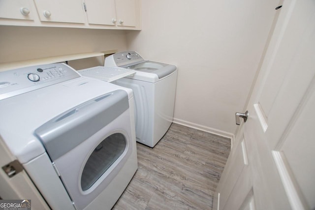 65 Pine Haven Ct, Carrollton, GA 30116 - washroom featuring separate washer and dryer, cabinet space, light wood finished floors, and baseboards