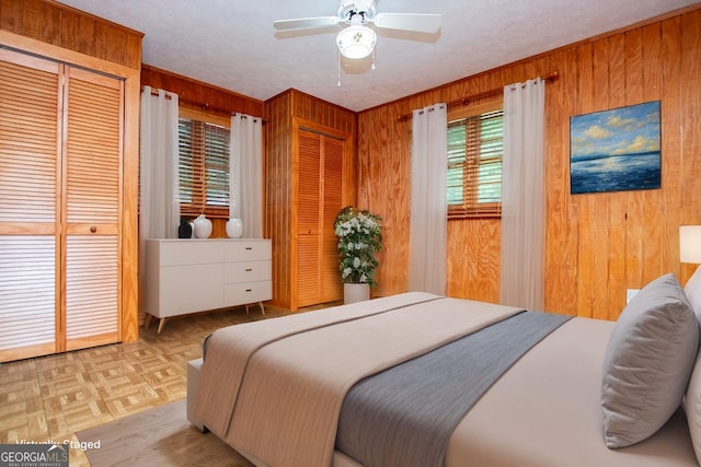 65 Pine Haven Ct, Carrollton, GA 30116 - bedroom featuring two closets, wood walls, and a ceiling fan
