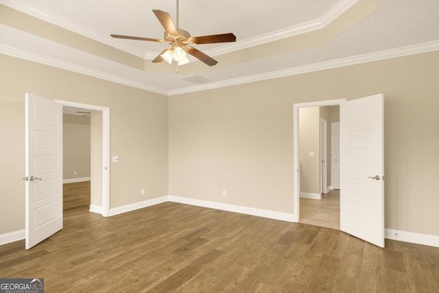 308 Laurel Landing Blvd, Kingsland, GA 31548 - spare room featuring crown molding, ceiling fan, wood finished floors, a tray ceiling, and baseboards