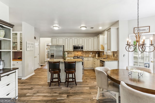 2624 E Madison Dr, Atlanta, GA 30360 - kitchen with appliances with stainless steel finishes, a chandelier, a sink, tasteful backsplash, and dark wood-type flooring