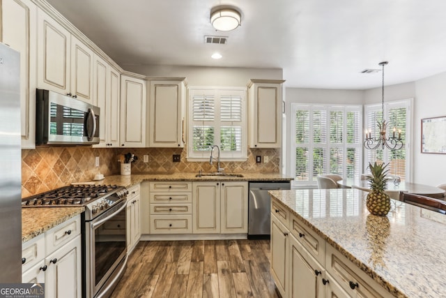 2624 E Madison Dr, Atlanta, GA 30360 - kitchen with appliances with stainless steel finishes, a sink, cream cabinets, dark wood-style flooring, and recessed lighting