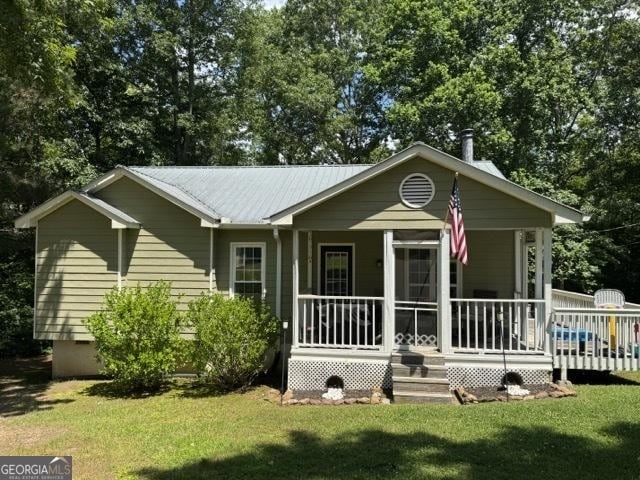 650 N Raburn Rd, Bremen, GA 30110 - view of front of home featuring a front lawn, a porch, metal roof, and view of wooded area