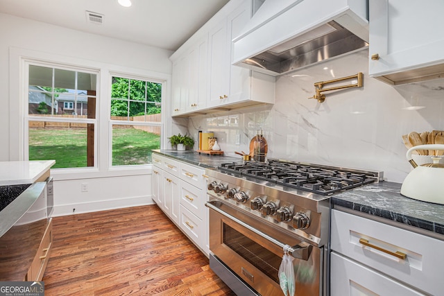 1721 S Gordon St SW, Atlanta, GA 30310 - kitchen featuring stainless steel range, premium range hood, white cabinets, light wood-style floors, and backsplash