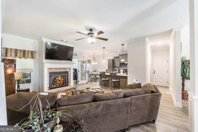 128 Arbor Crk, Warner Robins, GA 31093 - living room featuring crown molding, a ceiling fan, a brick fireplace, light wood finished floors, and baseboards
