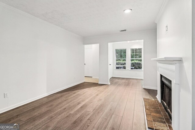 1931 Brian Way, Decatur, GA 30033 - unfurnished living room with a fireplace with raised hearth, wood finished floors, and crown molding