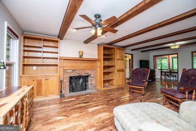 3187 Oak Grove Church Rd, Carrollton, GA 30117 - living area with beam ceiling, wood finished floors, a ceiling fan, and a fireplace