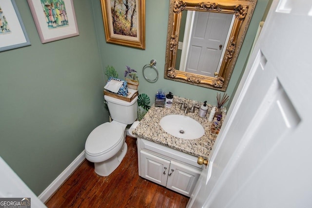 3187 Oak Grove Church Rd, Carrollton, GA 30117 - half bath featuring vanity, toilet, wood finished floors, and baseboards