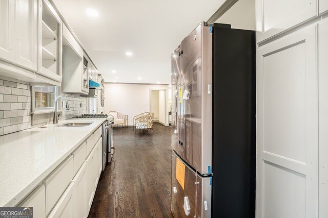2695 Peeler Rd, Dunwoody, GA 30360 - kitchen featuring stainless steel appliances, dark wood finished floors, a sink, tasteful backsplash, and white cabinetry