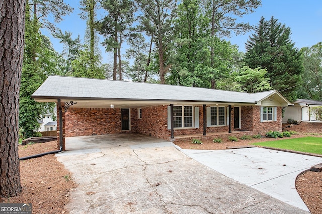 2695 Peeler Rd, Dunwoody, GA 30360 - single story home with concrete driveway, brick siding, and a carport