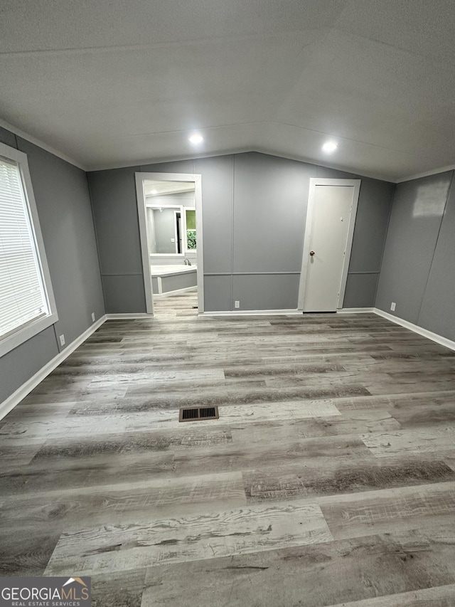 19 Poole Cir, Ellenwood, GA 30294 - unfurnished living room with wood finished floors, lofted ceiling, baseboards, and healthy amount of natural light