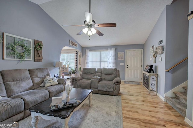 62 Lazy Water Dr SW, Cartersville, GA 30120 - living area featuring lofted ceiling, light wood-type flooring, ceiling fan, arched walkways, and stairs