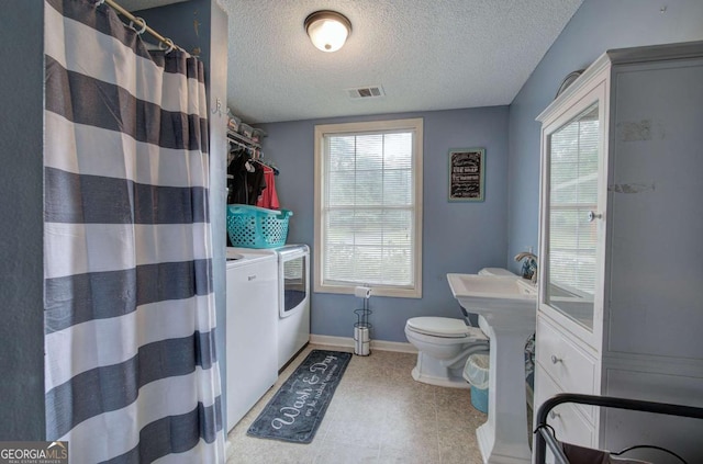 62 Lazy Water Dr SW, Cartersville, GA 30120 - full bathroom featuring washer and clothes dryer, a textured ceiling, healthy amount of natural light, and curtained shower