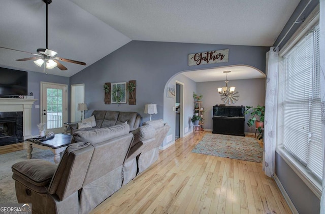 62 Lazy Water Dr SW, Cartersville, GA 30120 - living room featuring arched walkways, a premium fireplace, light wood-style flooring, a chandelier, and ceiling fan
