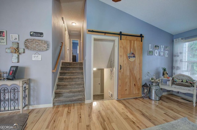 62 Lazy Water Dr SW, Cartersville, GA 30120 - staircase featuring vaulted ceiling, wood finished floors, and a barn door