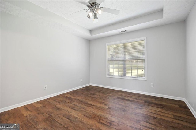 7825 Running Fox Trl, Gainesville, GA 30506 - spare room with a tray ceiling, dark wood finished floors, ceiling fan, and a textured ceiling