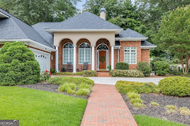 311 Vinings Walk, Gainesville, GA 30501 - traditional-style home featuring roof with shingles, a porch, a chimney, an attached garage, and brick siding