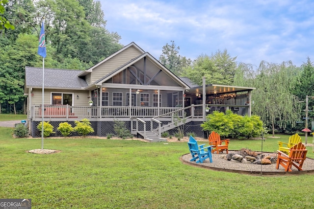 4505 Mccullum Trl, Hiawassee, GA 30546 - rear view of property with an outdoor fire pit, a sunroom, a deck, roof with shingles, and a yard