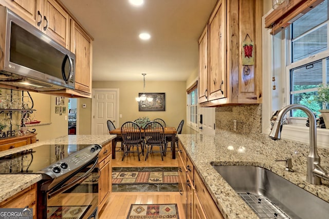 4505 Mccullum Trl, Hiawassee, GA 30546 - kitchen with stainless steel microwave, a sink, black electric range, hardwood / wood-style flooring, and a chandelier