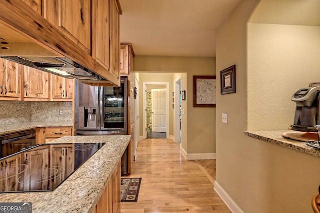 4505 Mccullum Trl, Hiawassee, GA 30546 - kitchen with black electric cooktop, stainless steel fridge, light wood-style flooring, and light stone counters