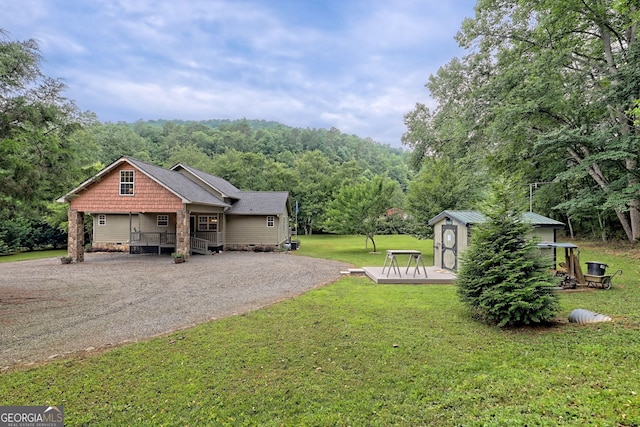 4505 Mccullum Trl, Hiawassee, GA 30546 - view of green lawn with dirt driveway, a forest view, and a wooden deck