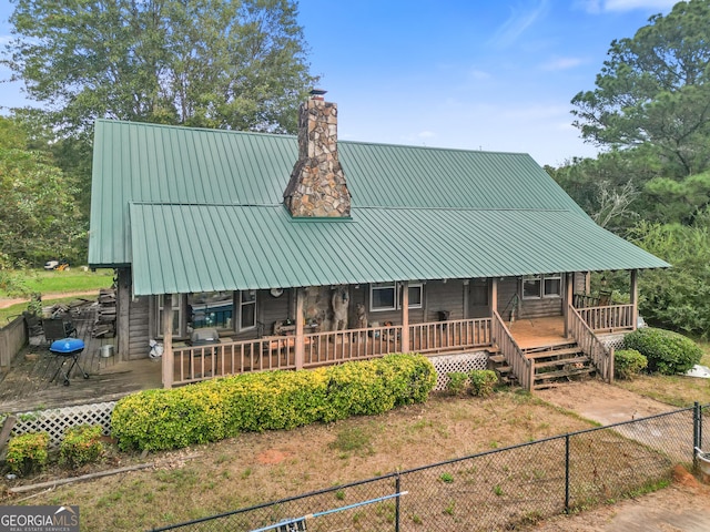 223 Arthur Rd, Zebulon, GA 30295 - view of front of house with a chimney, a fenced backyard, metal roof, covered porch, and a wooden deck