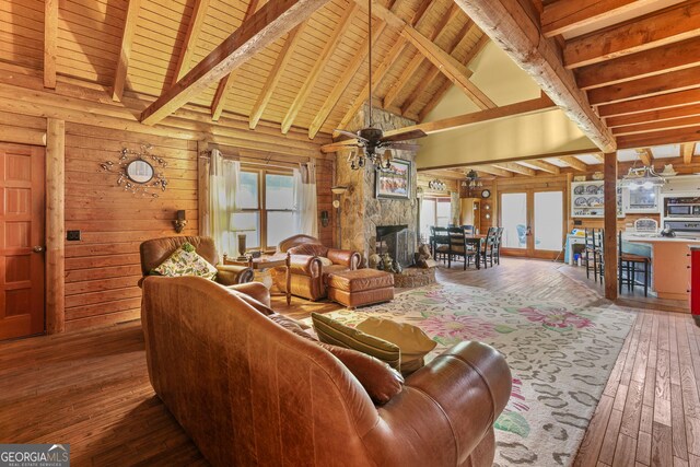 223 Arthur Rd, Zebulon, GA 30295 - living area featuring hardwood / wood-style floors, wood ceiling with exposed beams, high vaulted ceiling, a stone fireplace, and a ceiling fan
