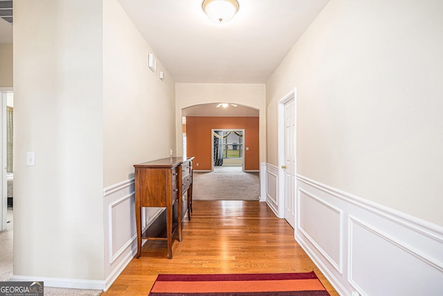 4200 Vinca Way, Union City, GA 30291 - hallway featuring arched walkways, light wood-style floors, wainscoting, and a decorative wall