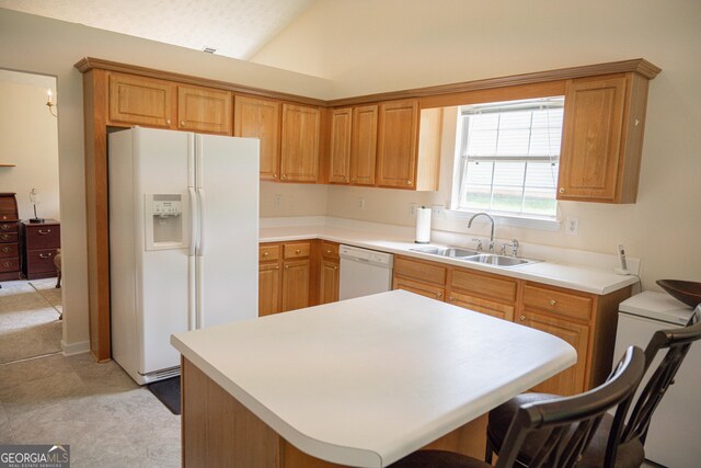 2407 Cove Lake Way, Lithonia, GA 30058 - kitchen featuring white appliances, vaulted ceiling, light countertops, a kitchen island, and a kitchen breakfast bar