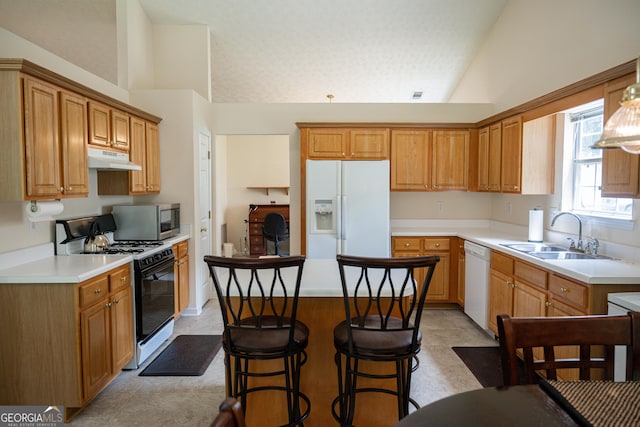 2407 Cove Lake Way, Lithonia, GA 30058 - kitchen featuring white appliances, under cabinet range hood, vaulted ceiling, a kitchen island, and light countertops