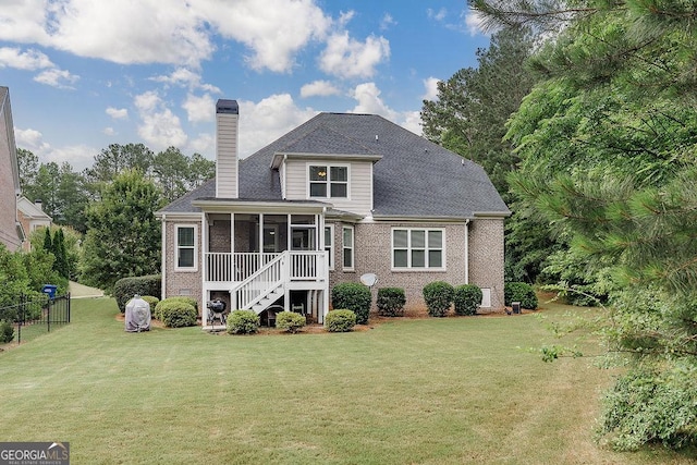 1015 Turtle Pond Dr, Watkinsville, GA 30677 - back of property with a sunroom, a chimney, brick siding, and stairway