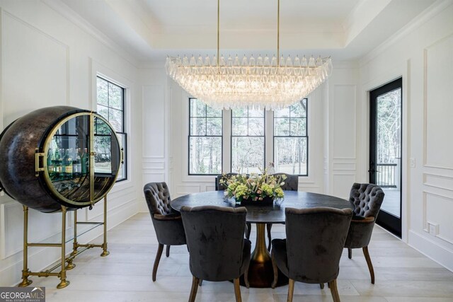 5050 Browns Ford Rd, Greensboro, GA 30642 - dining area with a decorative wall, a chandelier, a raised ceiling, light wood-style floors, and crown molding