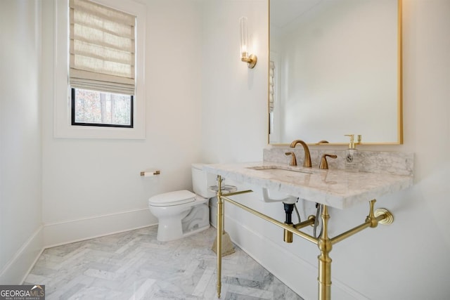5050 Browns Ford Rd, Greensboro, GA 30642 - bathroom featuring toilet, a sink, baseboards, and marble look tiles