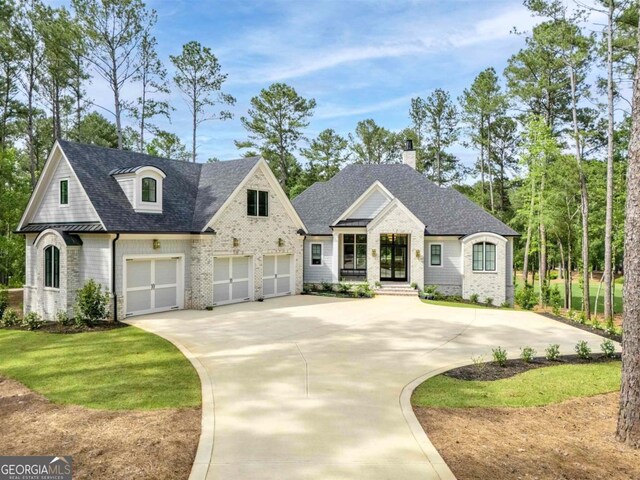 5050 Browns Ford Rd, Greensboro, GA 30642 - french country style house with concrete driveway, brick siding, a chimney, and a shingled roof