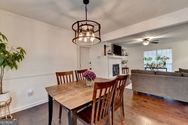 3694 Jay Bird Aly, Peachtree Corners, GA 30092 - dining room with wood finished floors, a glass covered fireplace, crown molding, a chandelier, and baseboards