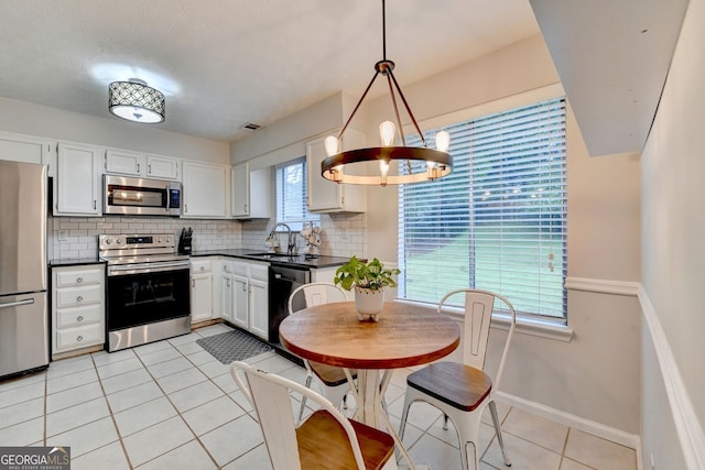 3694 Jay Bird Aly, Peachtree Corners, GA 30092 - kitchen featuring stainless steel appliances, dark countertops, a sink, and light tile patterned floors