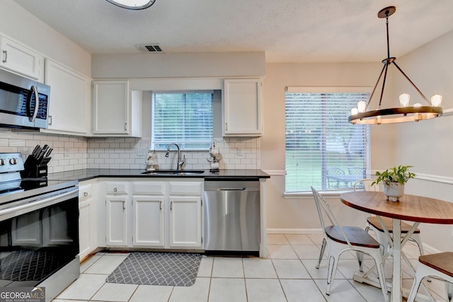 3694 Jay Bird Aly, Peachtree Corners, GA 30092 - kitchen with appliances with stainless steel finishes, a sink, dark countertops, white cabinets, and backsplash