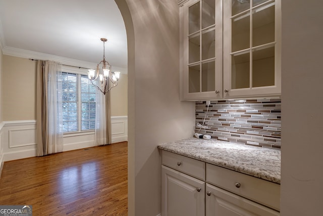 1984 Mendenhall Cir, Atlanta, GA 30341 - kitchen with a chandelier, arched walkways, glass insert cabinets, tasteful backsplash, and wood finished floors