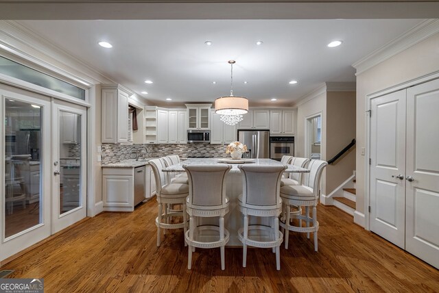 1984 Mendenhall Cir, Atlanta, GA 30341 - kitchen with appliances with stainless steel finishes, crown molding, tasteful backsplash, a kitchen bar, and a kitchen island