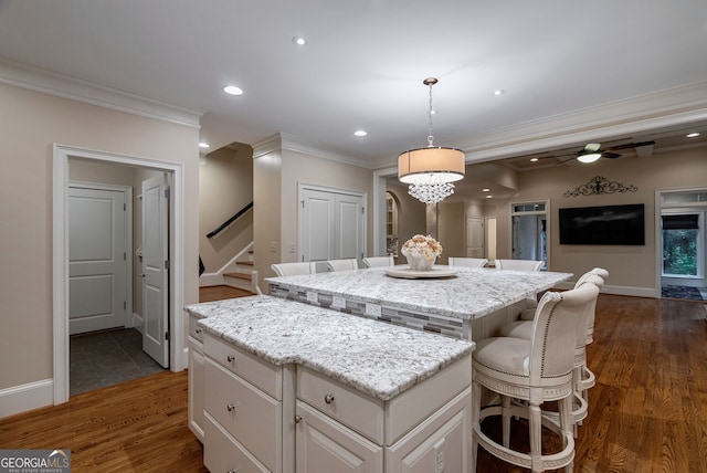 1984 Mendenhall Cir, Atlanta, GA 30341 - kitchen featuring a kitchen island, dark wood-style floors, a breakfast bar, crown molding, and recessed lighting