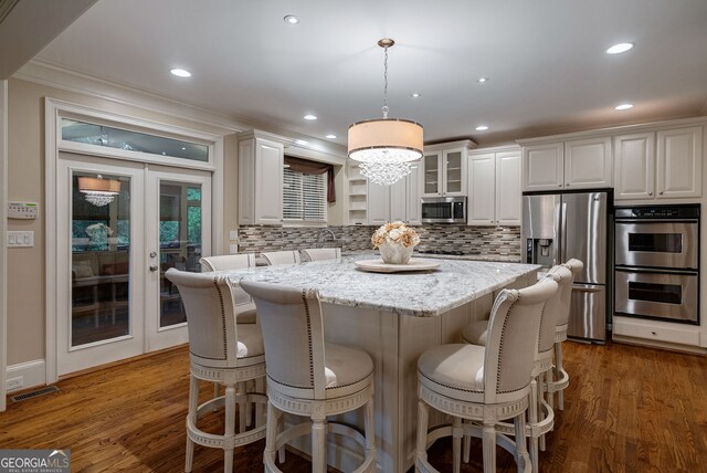 1984 Mendenhall Cir, Atlanta, GA 30341 - kitchen with stainless steel appliances, crown molding, tasteful backsplash, a kitchen bar, and french doors