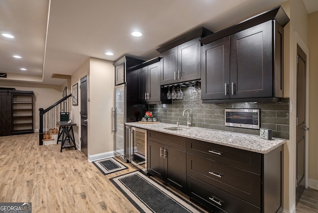 1984 Mendenhall Cir, Atlanta, GA 30341 - kitchen featuring wine cooler, stainless steel microwave, light wood finished floors, decorative backsplash, and light stone countertops