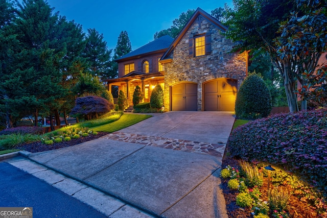 1984 Mendenhall Cir, Atlanta, GA 30341 - view of front of home featuring stone siding, driveway, a garage, and a porch