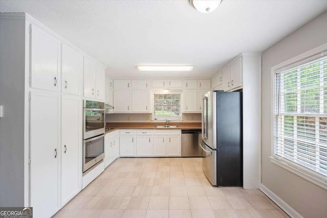 3802 Birchbriar Ct, Decatur, GA 30034 - kitchen with stainless steel appliances, a sink, healthy amount of natural light, and white cabinetry